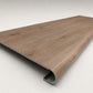 Custom round-nose stair tread made from A&A Surfaces Forrest Brown flooring. Round profile. Angled view.