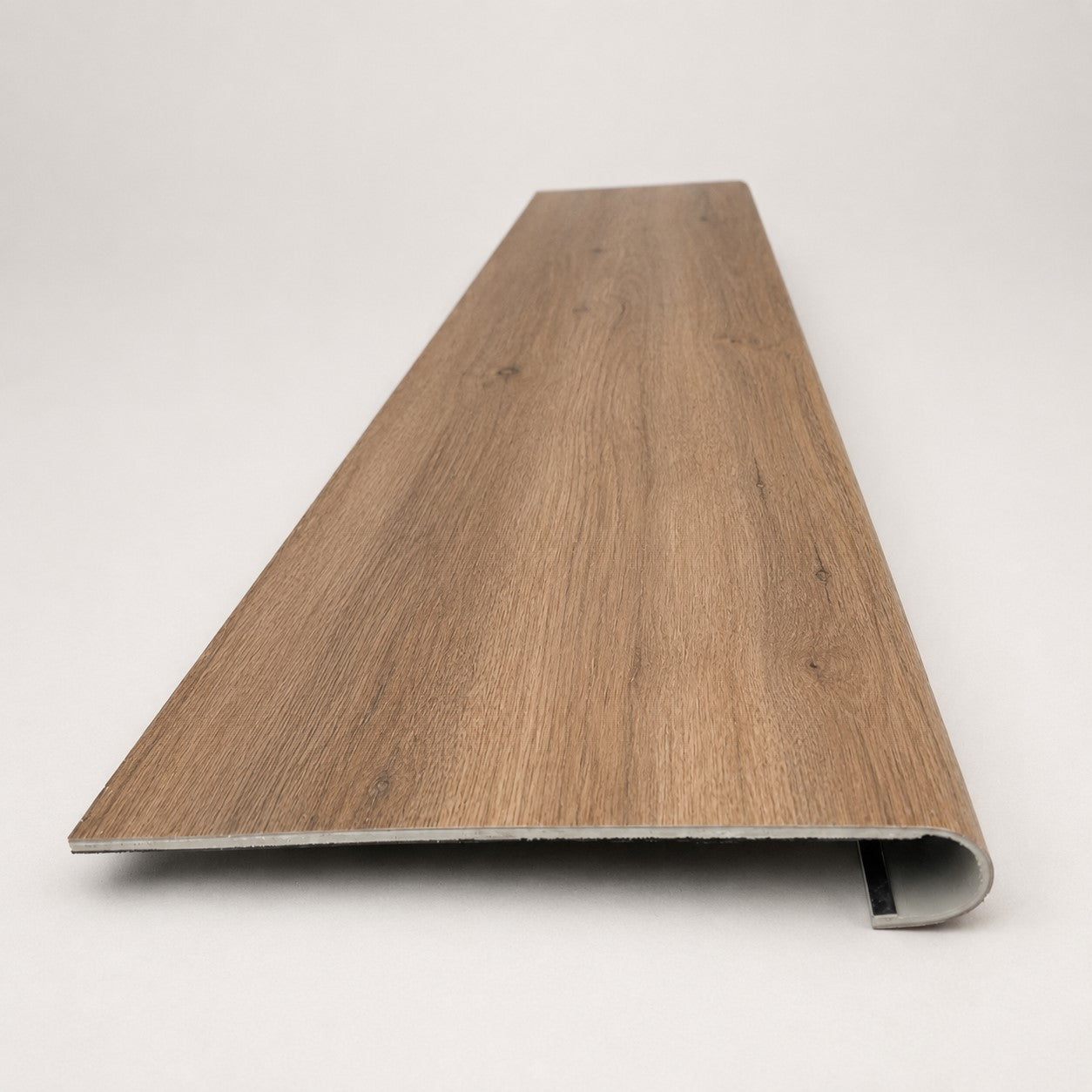 Custom round-nose stair tread made from A&A Surfaces Forrest Brown flooring. Round profile. Front view.