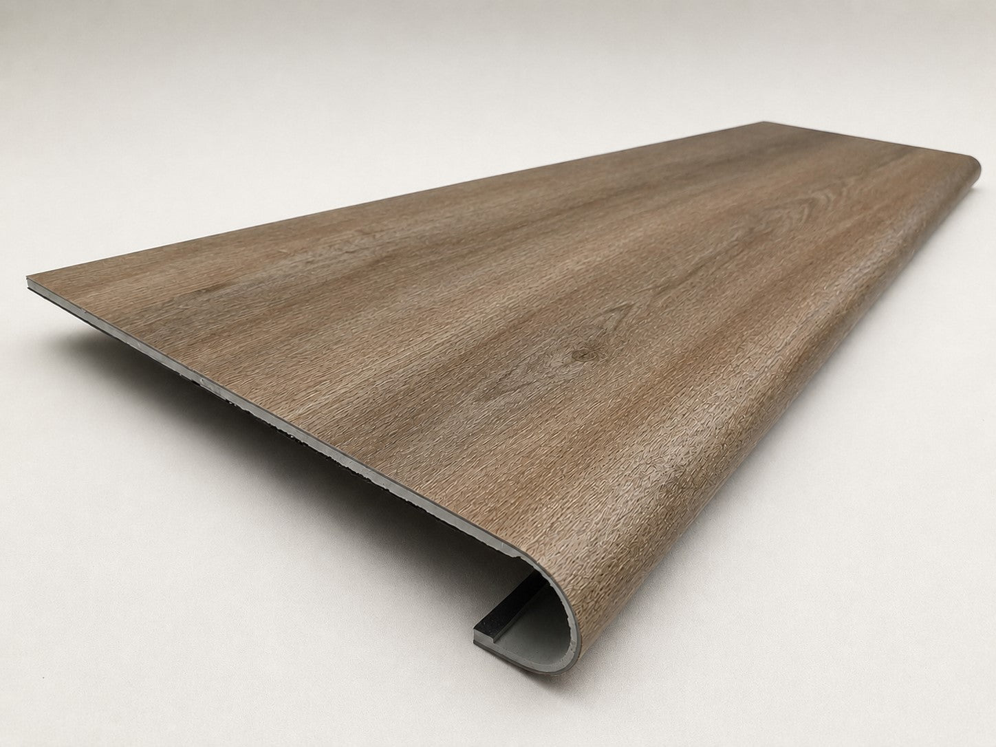 Custom round-nose stair tread made from DuraLux Performance Alamo Oak flooring. Round profile. Angled view