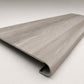 Custom round-nose stair tread made from DuraLux Performance Highguard Silver flooring. Round profile. Angled view.