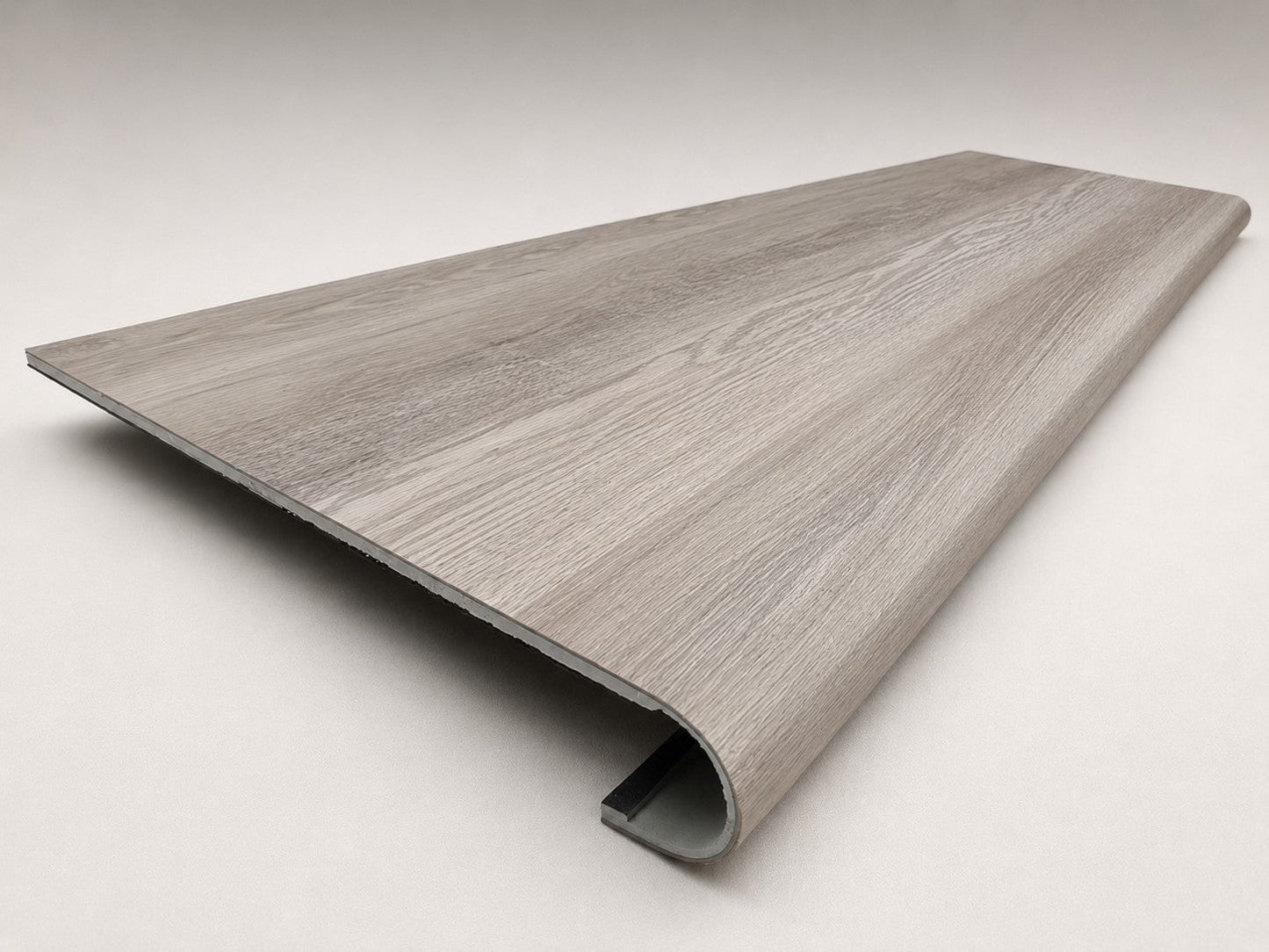 Custom round-nose stair tread made from DuraLux Performance Highguard Silver flooring. Round profile. Angled view.