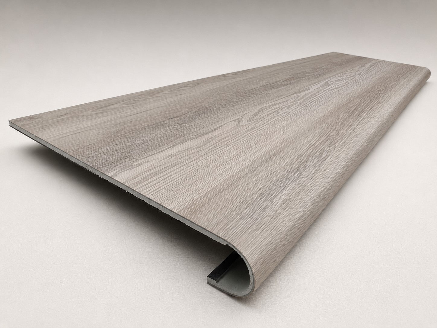 Custom round-nose stair tread made from DuraLux Performance Highguard Silver flooring. Round profile. Angled view.