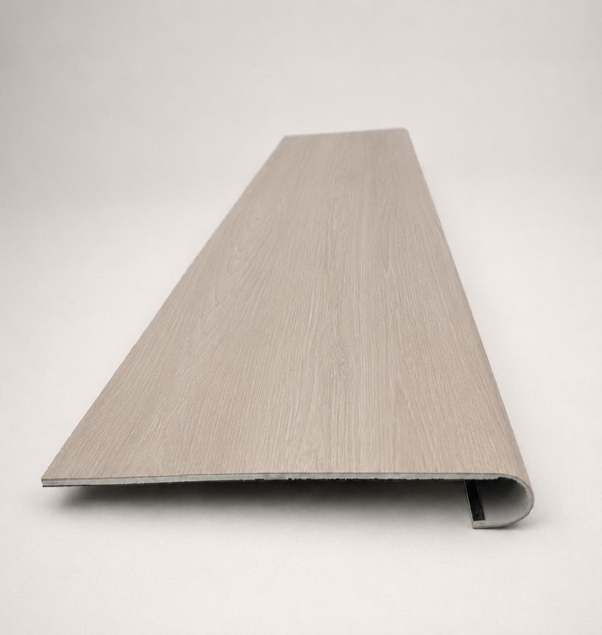 Custom round-nose stair tread made from DuraLux Performance Lorraine Sienna flooring. Round profile. Front view.