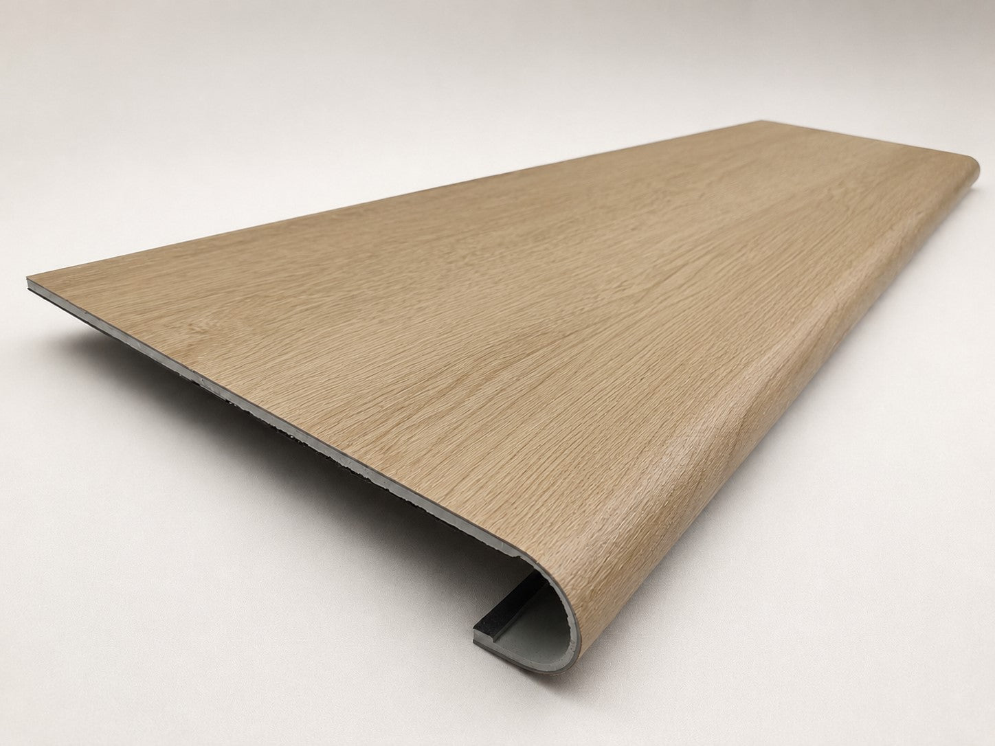 Custom round-nose stair tread made from DuraLux Performance Paisley Cape flooring. Round profile. Angled view.