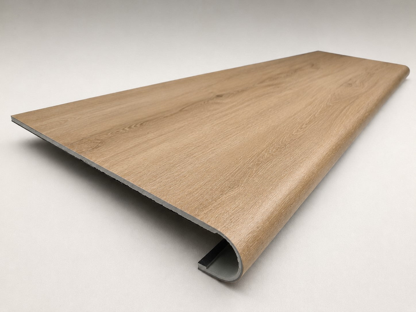 Custom round-nose stair tread made from DuraLux Performance Piedmont Bend flooring. Round profile. Angled view.