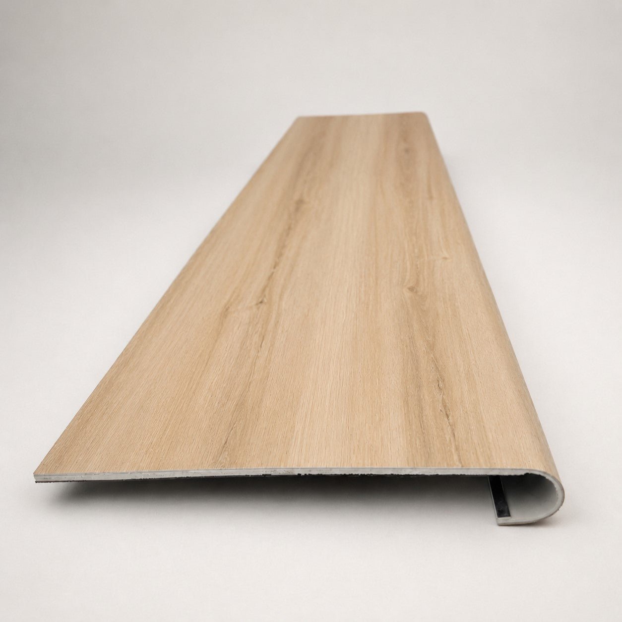 Custom round-nose stair tread made from DuraLux Performance Piedmont Bend flooring. Round profile. Front view.
