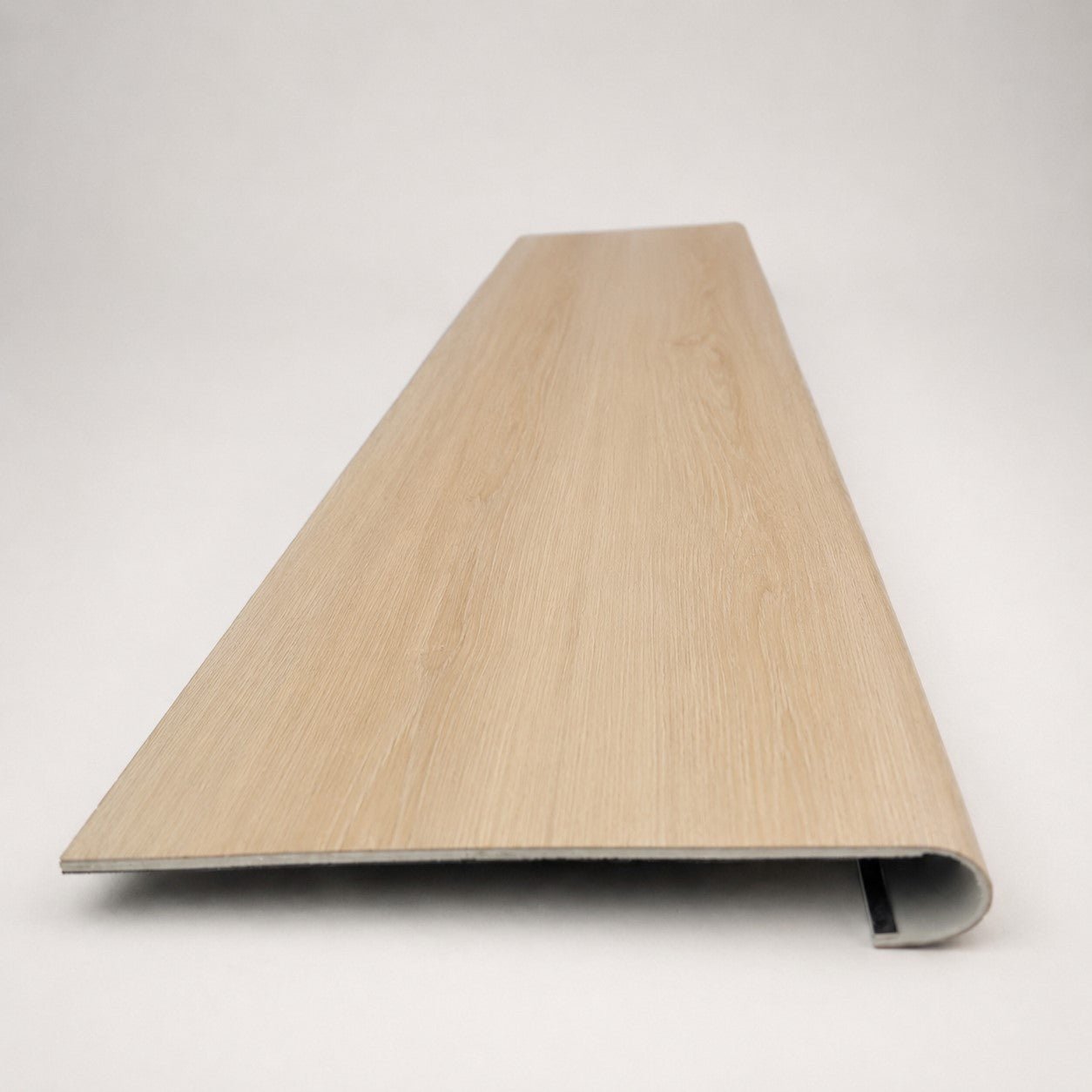Custom round-nose stair tread made from DuraLux Performance Poplar Trace flooring. Round profile. Front view.