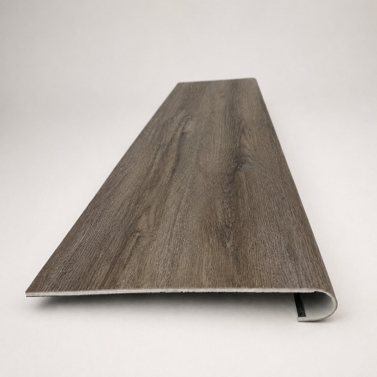 Custom round-nose stair tread made from DuraLux Performance Stormy Elm flooring. Round profile. Front view.