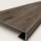 Custom square-nose stair tread made from DuraLux Performance Stormy Elm flooring. Square profile. Angled view.
