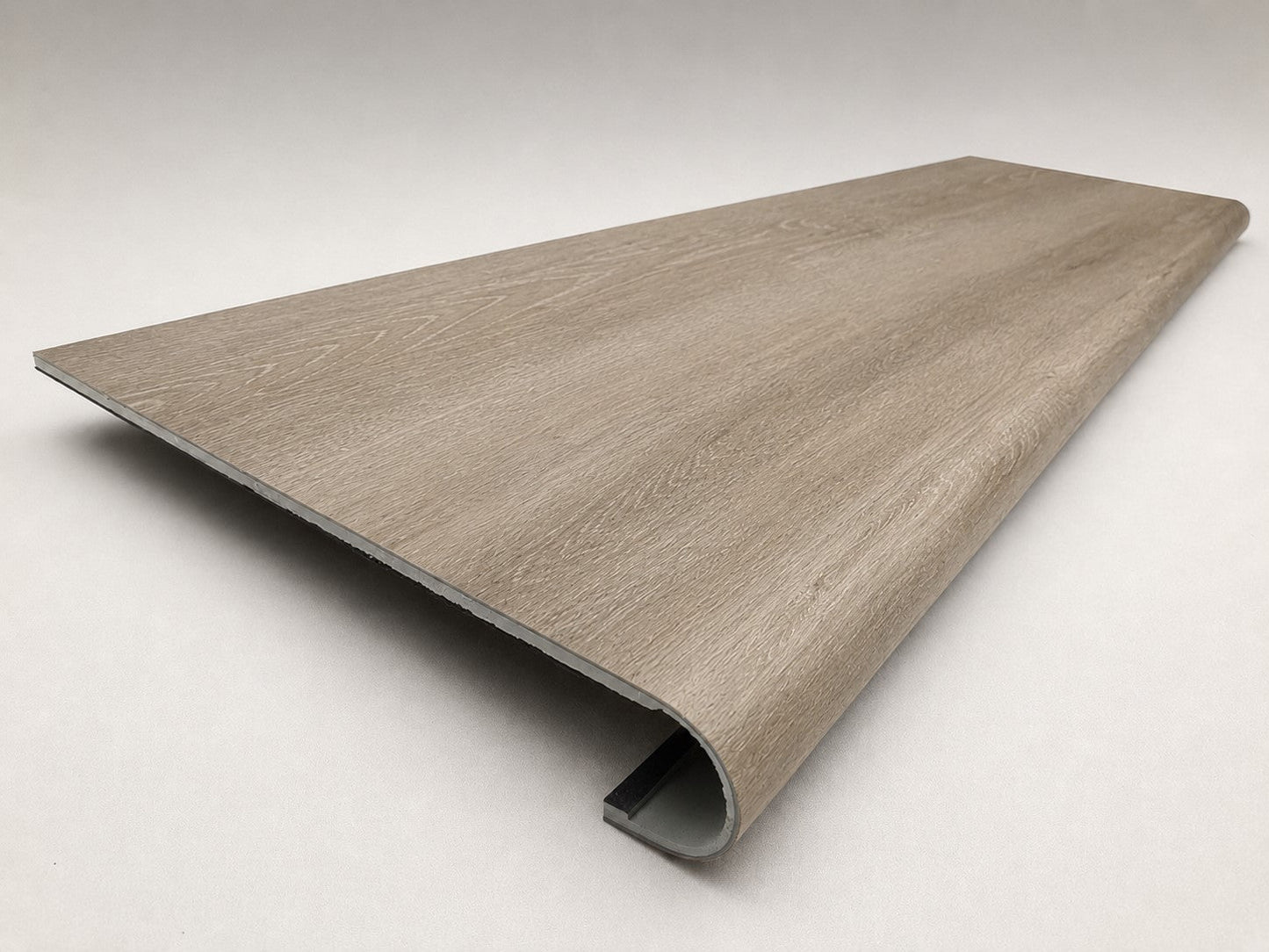 Custom round-nose stair tread made from DuraLux Performance Timber Saddle flooring. Round profile. Angled view.