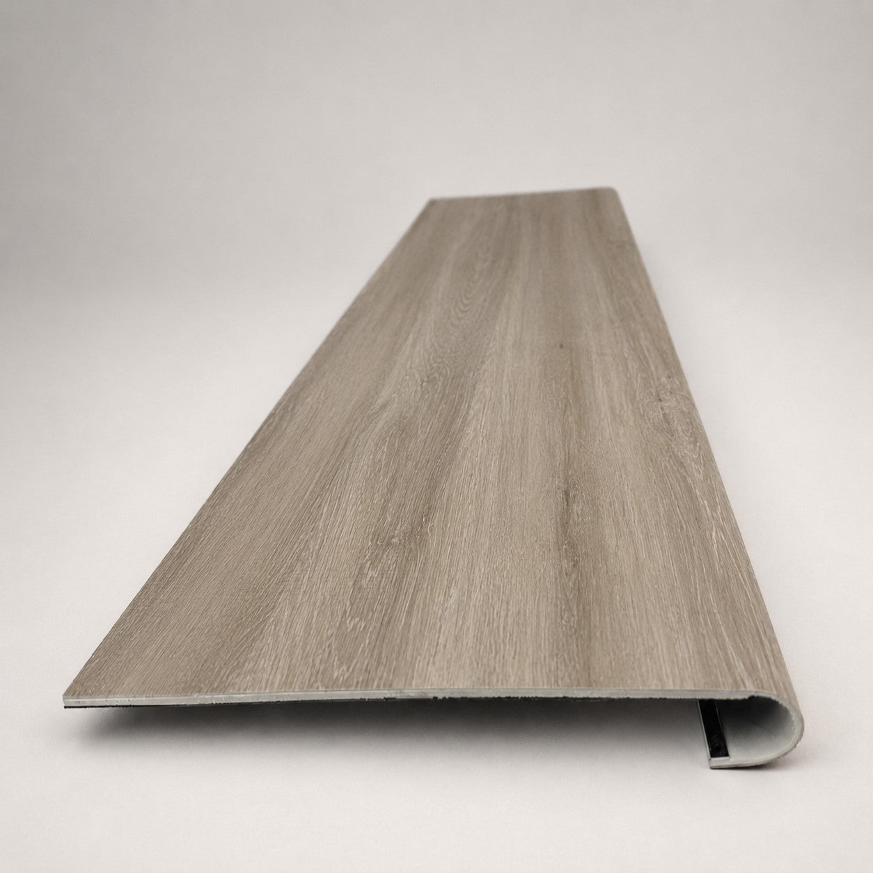 Custom round-nose stair tread made from DuraLux Performance Timber Saddle flooring. Round profile. Front view.