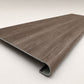 Custom round-nose stair tread made from DuraLux Performance Winter Peak flooring. Round profile. Angled view.