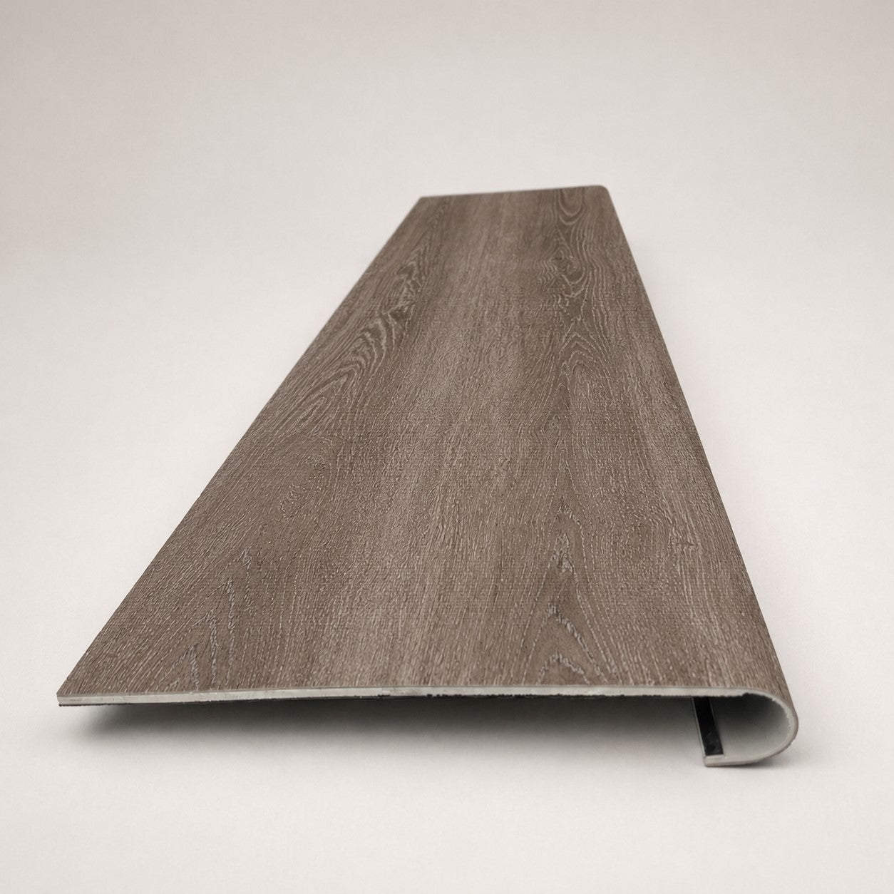 Custom round-nose stair tread made from DuraLux Performance Winter Peak flooring. Round profile. Front view.