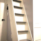 Painted white MDF stair riser installed on a staircase leading to a loft, shown as a finished example of a custom stair component.