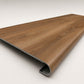 Custom round-nose stair tread made to match LifeProof Butler Hickory flooring. Round profile. Angled view.