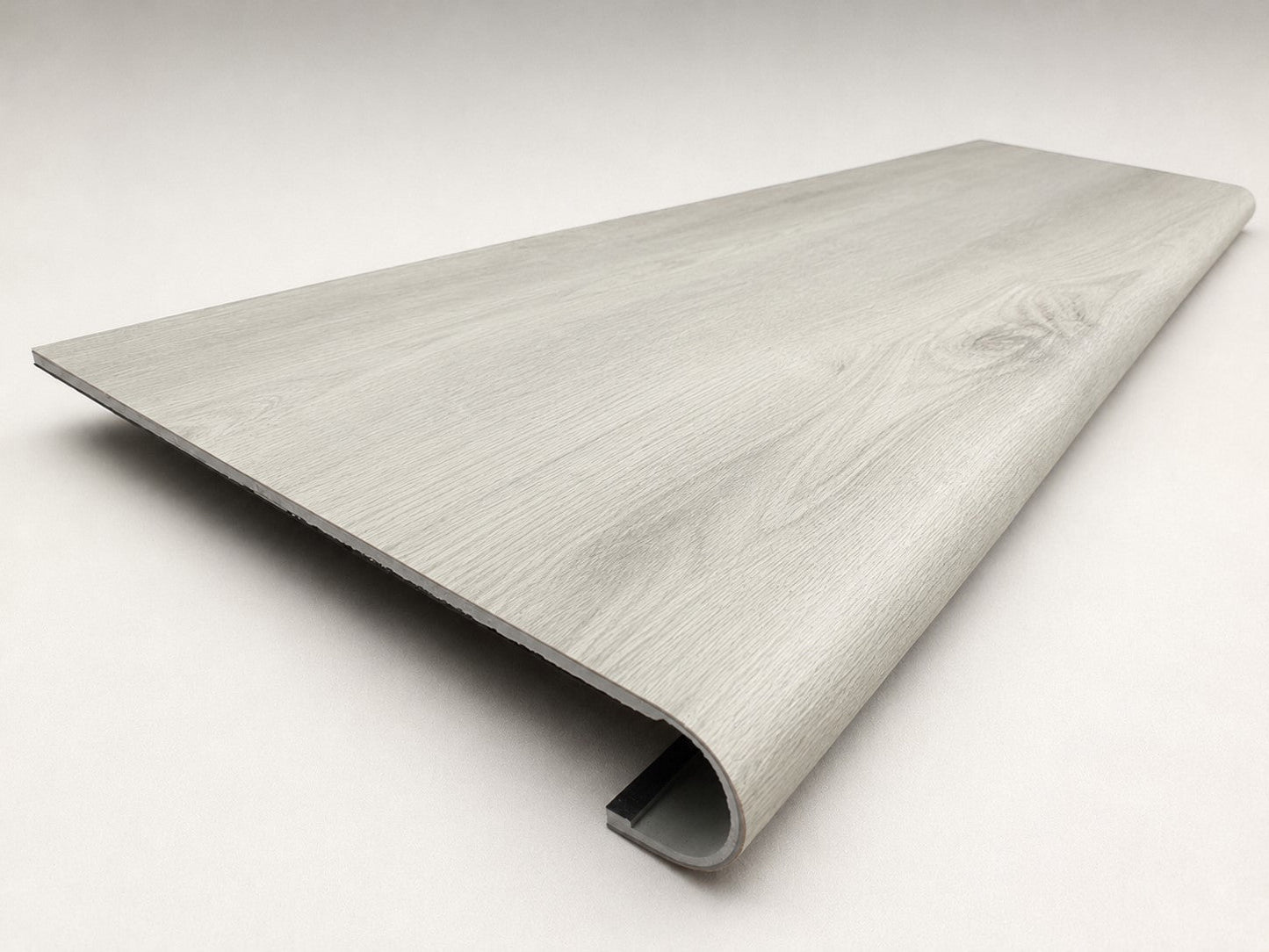 Custom round-nose stair tread made from LifeProof Chiffon Lace flooring. Round profile. Angled view.