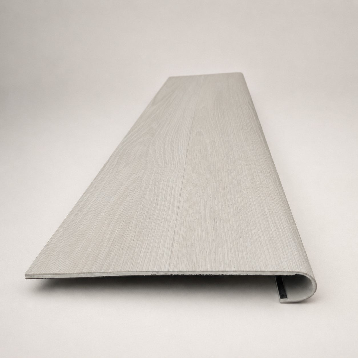 Custom round-nose stair tread made from LifeProof Driftwood Beach Oak flooring. Round profile. Front view.