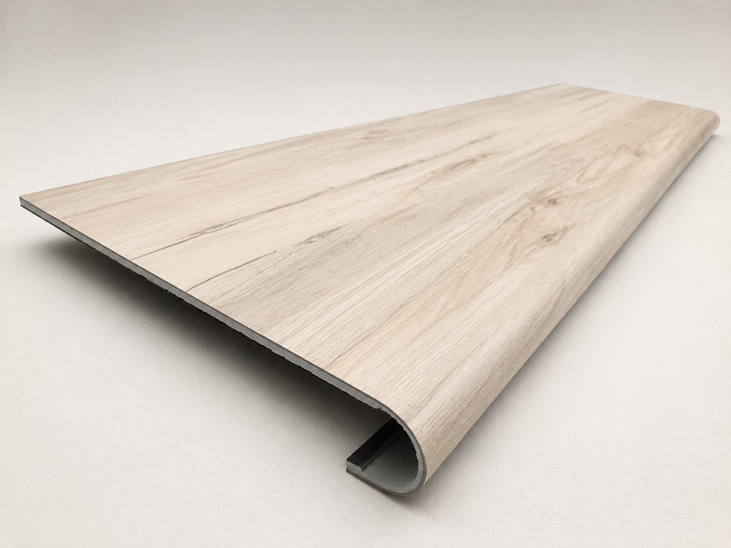 Custom round-nose stair tread made from LifeProof Navarra Maple Oak flooring. Round profile. Angled view.
