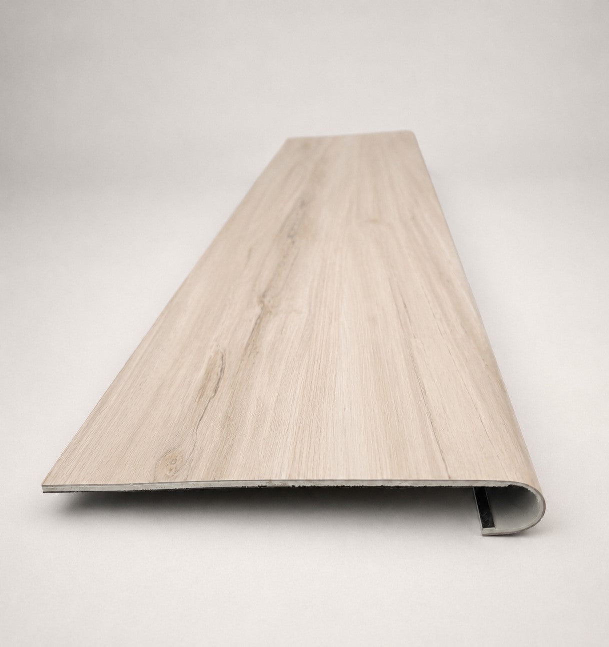 Custom round-nose stair tread made from LifeProof Navarra Maple Oak flooring. Round profile. Front view.