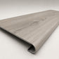 Custom round-nose stair tread made from LifeProof Sterling Oak flooring. Round profile. Angled view.