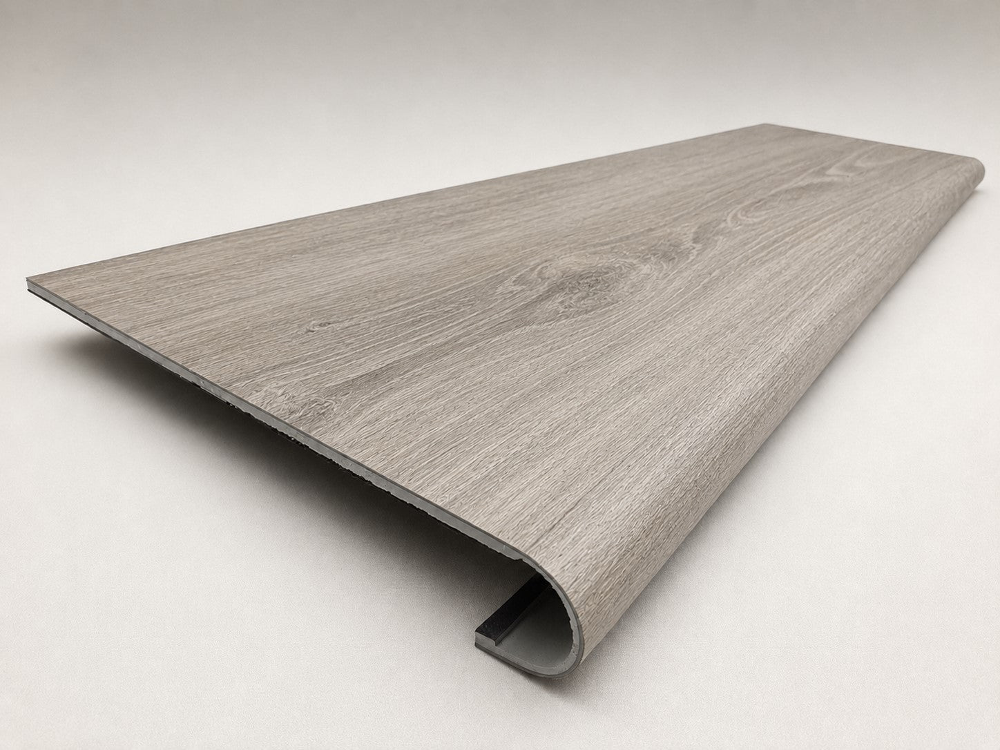 Custom round-nose stair tread made from LifeProof Sterling Oak flooring. Round profile. Angled view.