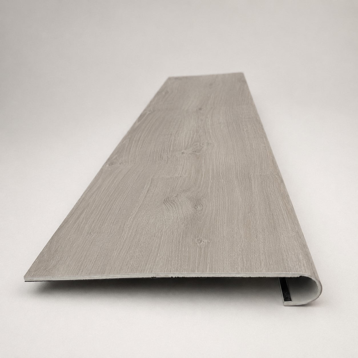 Custom round-nose stair tread made from LifeProof Sterling Oak flooring. Round profile. Front view.