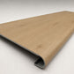 Custom round-nose stair tread made from NuCore Cedar Point flooring. Round profile. Angled view.