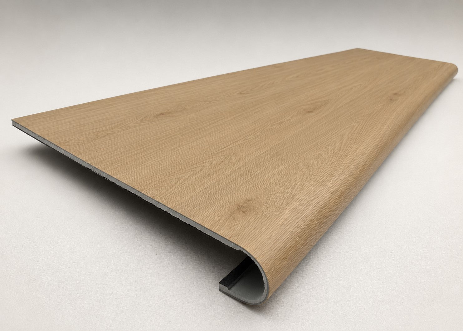Custom round-nose stair tread made from NuCore Cedar Point flooring. Round profile. Angled view.
