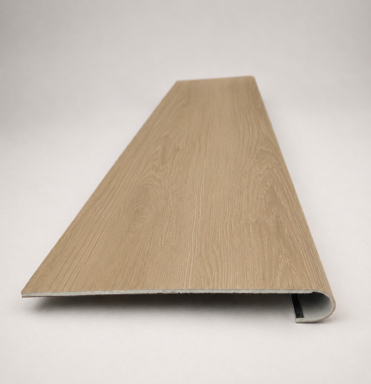 Custom round-nose stair tread made from NuCore Cedar Point flooring. Round profile. Front view.