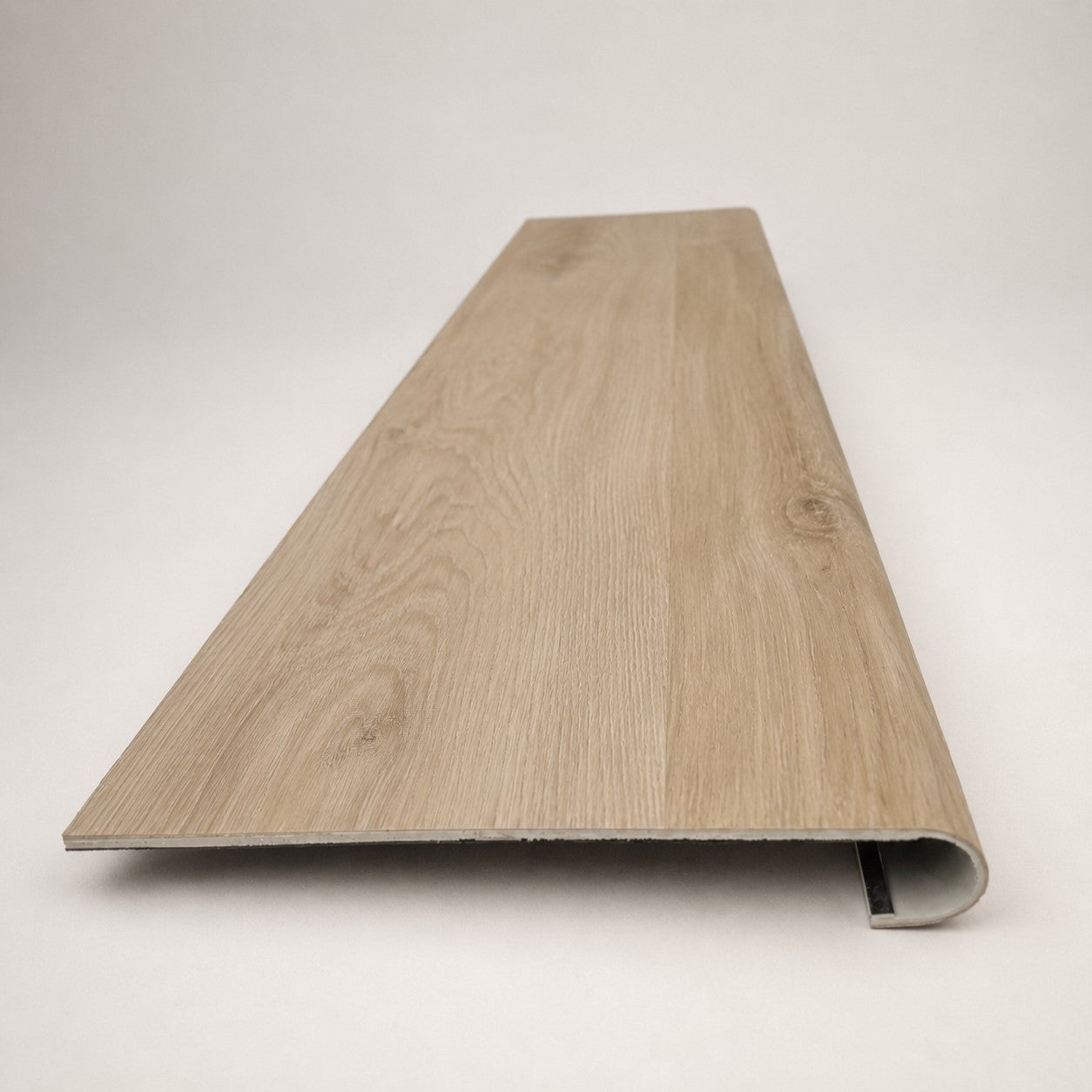 Custom round-nose stair tread made to match NuCore Deerfield Grove flooring. Round profile. Front view.