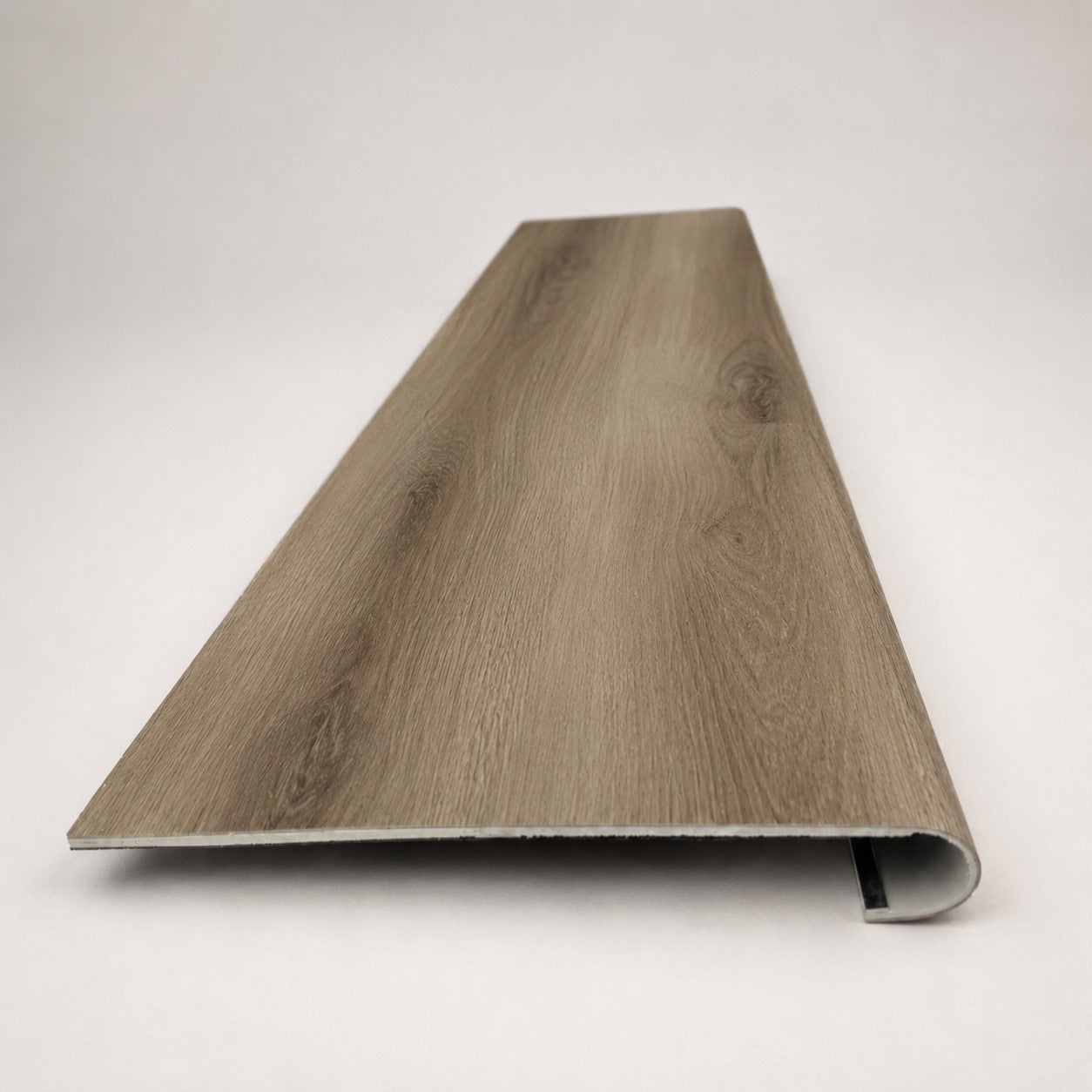 Custom round-nose stair tread made from NuCore Everwood Falls flooring. Round profile. Front view.
