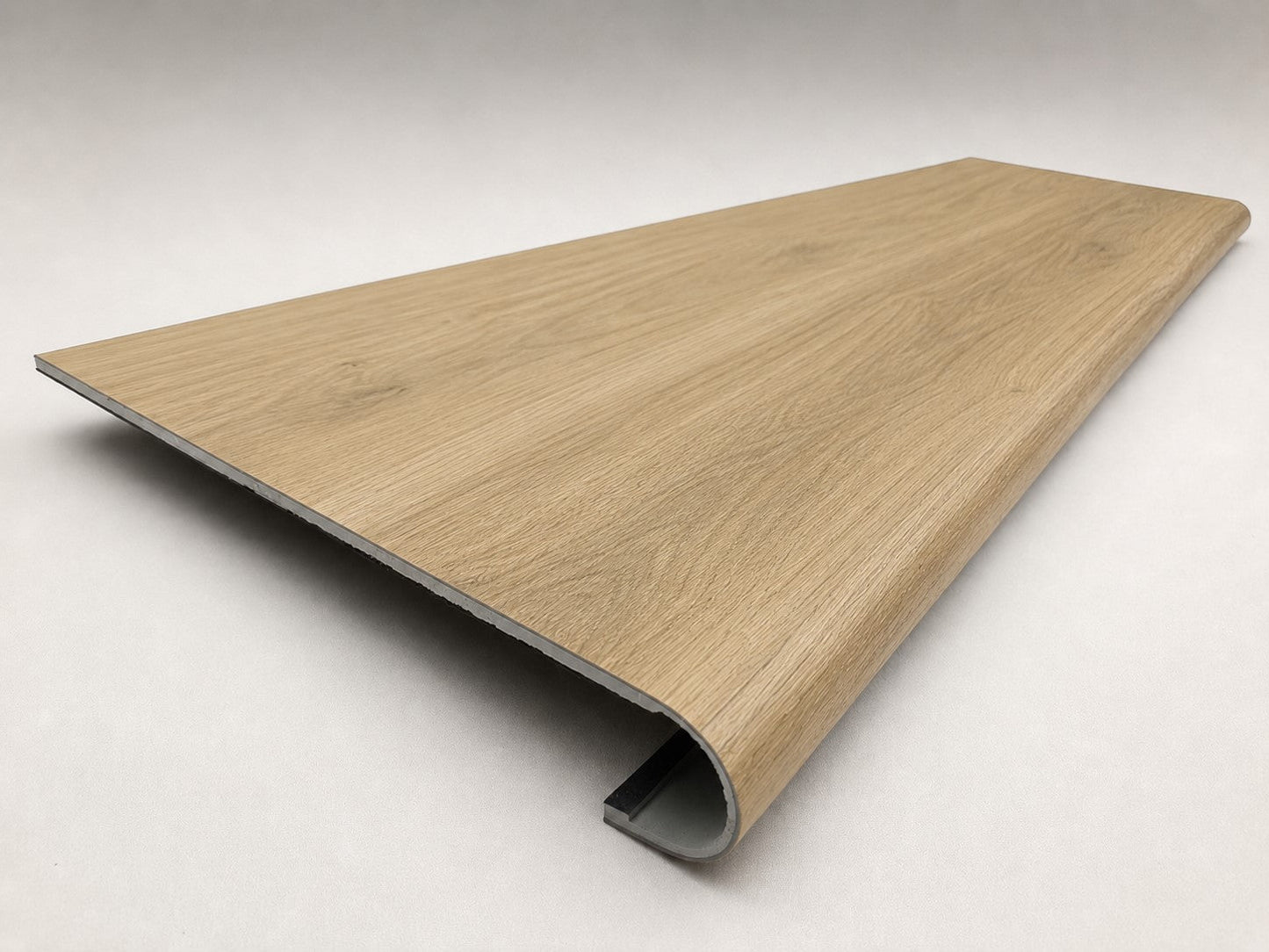 Custom round-nose stair tread made to match NuCore Fairborn Blonde flooring. Round profile. Angled view.