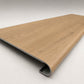 Custom round-nose stair tread made from NuCore Glenridge Oak flooring. Round profile. Angled view.