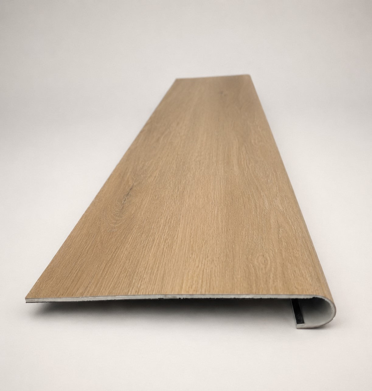 Custom round-nose stair tread made from NuCore Glenridge Oak flooring. Round profile. Front view.
