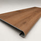 Custom round-nose stair tread made from NuCore Gunstock Oak flooring. Round profile. Angled view.