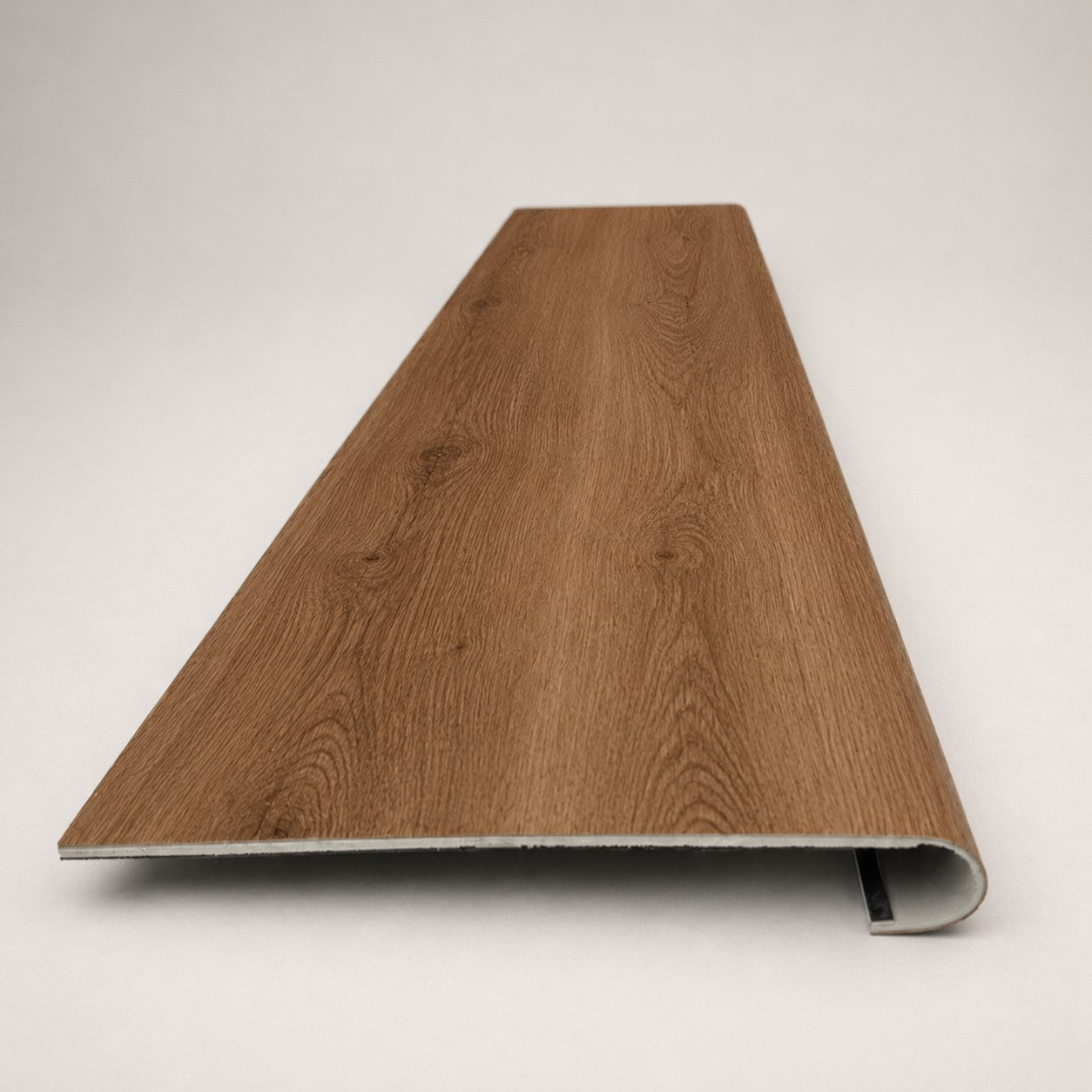 Custom round-nose stair tread made from NuCore Gunstock Oak flooring. Round profile. Front view.