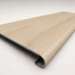 Custom round nose stair tread made from NuCore Nordic Oak flooring, showing a finished matching tread with light wood grain, smooth rounded profile, and professional product detail. Angled view