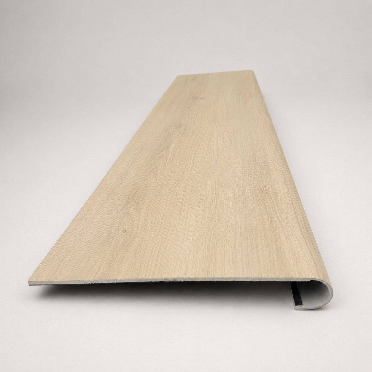 Custom round nose stair tread made from NuCore Nordic Oak flooring, showing a finished matching tread with light wood grain, smooth rounded profile, and professional product detail. Front View