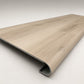 Custom round-nose stair tread made to match NuCore Turner Road flooring. Round profile. Angled view.