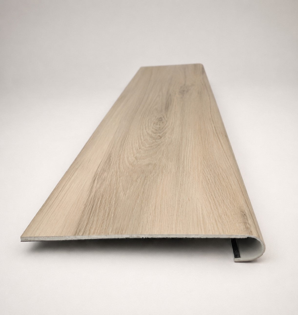 Custom round-nose stair tread made to match NuCore Turner Road flooring. Round profile. Front view.
