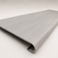 Custom round-nose stair tread made from NuCore Wisteria flooring. Round profile. Angled view.