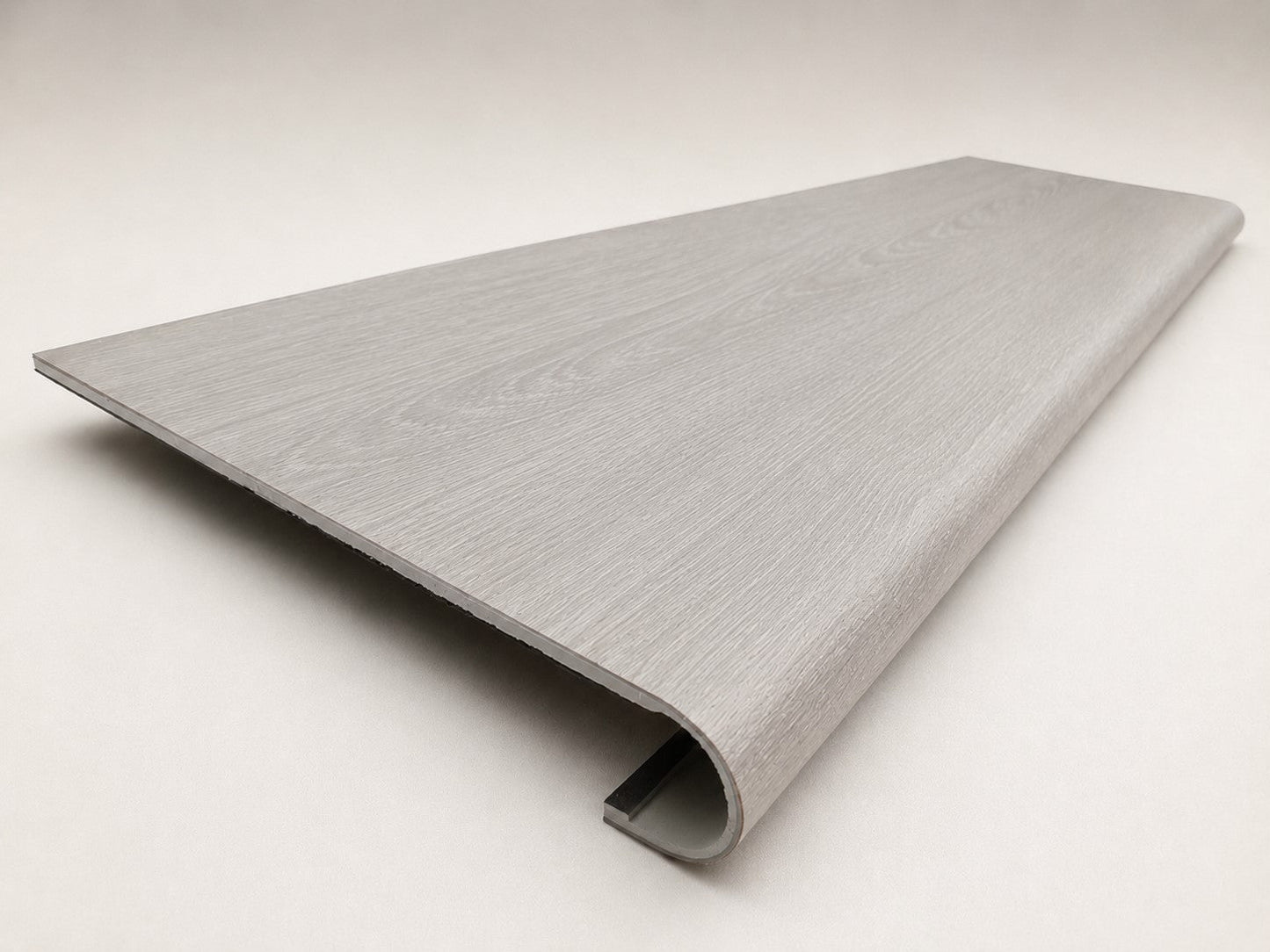 Custom round-nose stair tread made from NuCore Wisteria flooring. Round profile. Angled view.