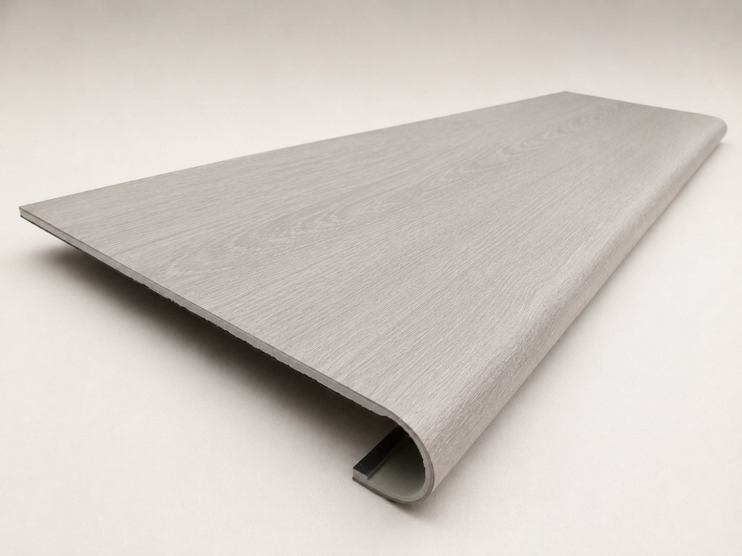 Custom round-nose stair tread made from NuCore Wisteria flooring. Round profile. Angled view.