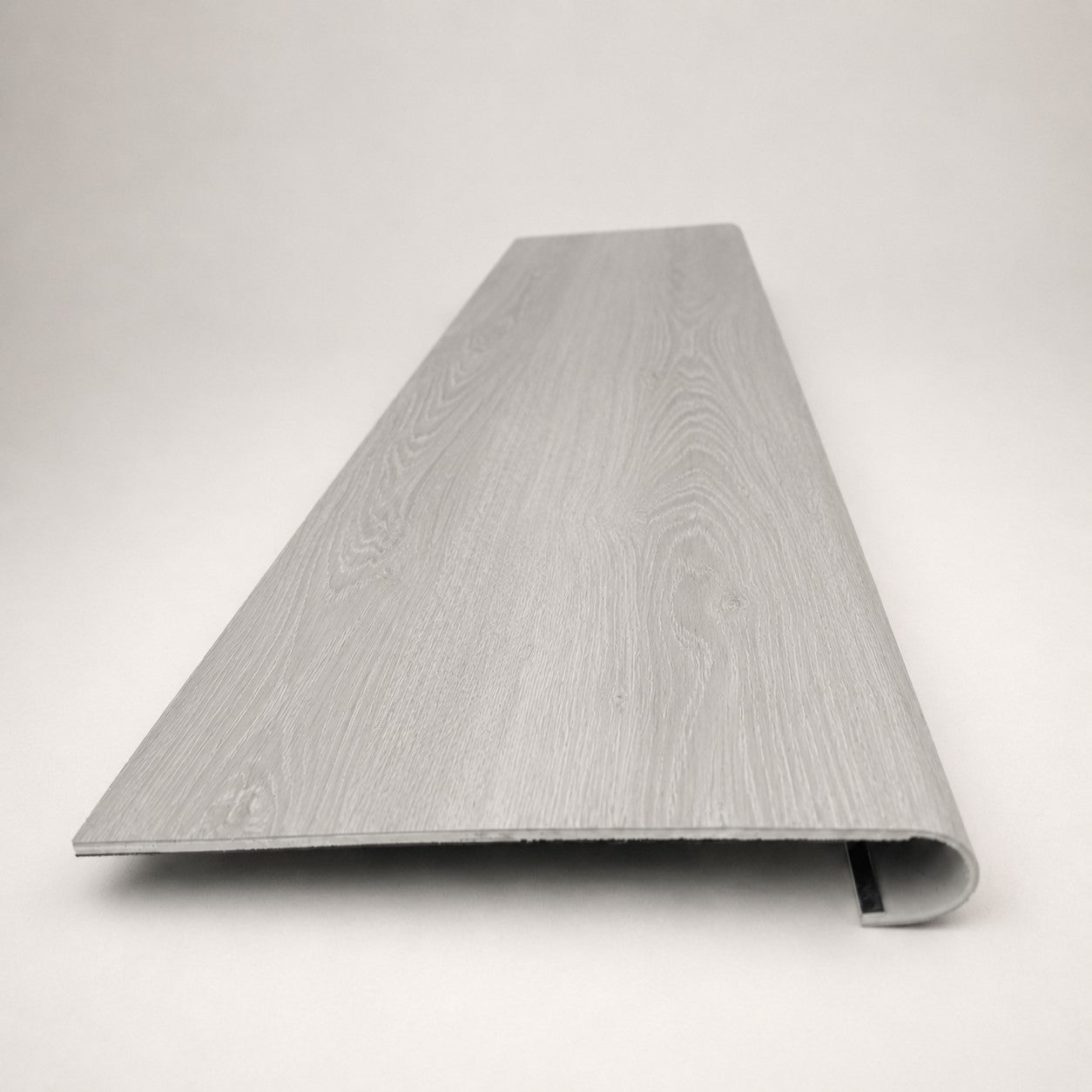 Custom round-nose stair tread made from NuCore Wisteria flooring. Round profile. Front view.