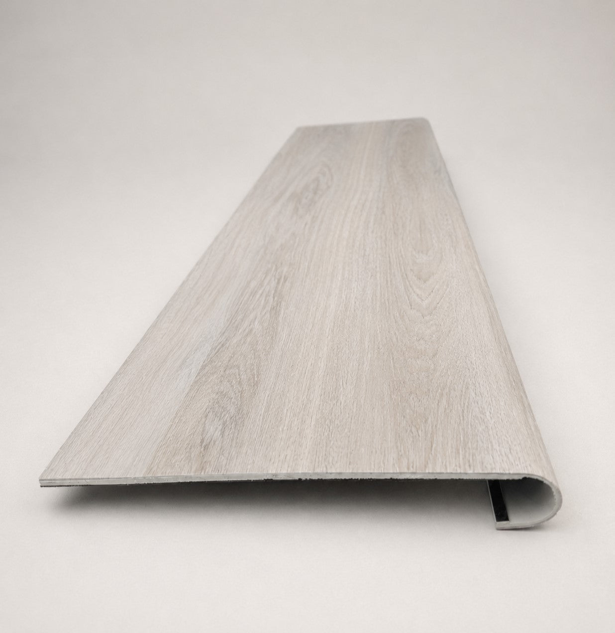 Custom round-nose stair tread made from STAINMASTER Sanderling Spruce flooring. Round profile. Front view.