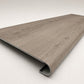Custom round-nose stair tread made from Style Selections Ashen Oak flooring. Round profile. Angled view.
