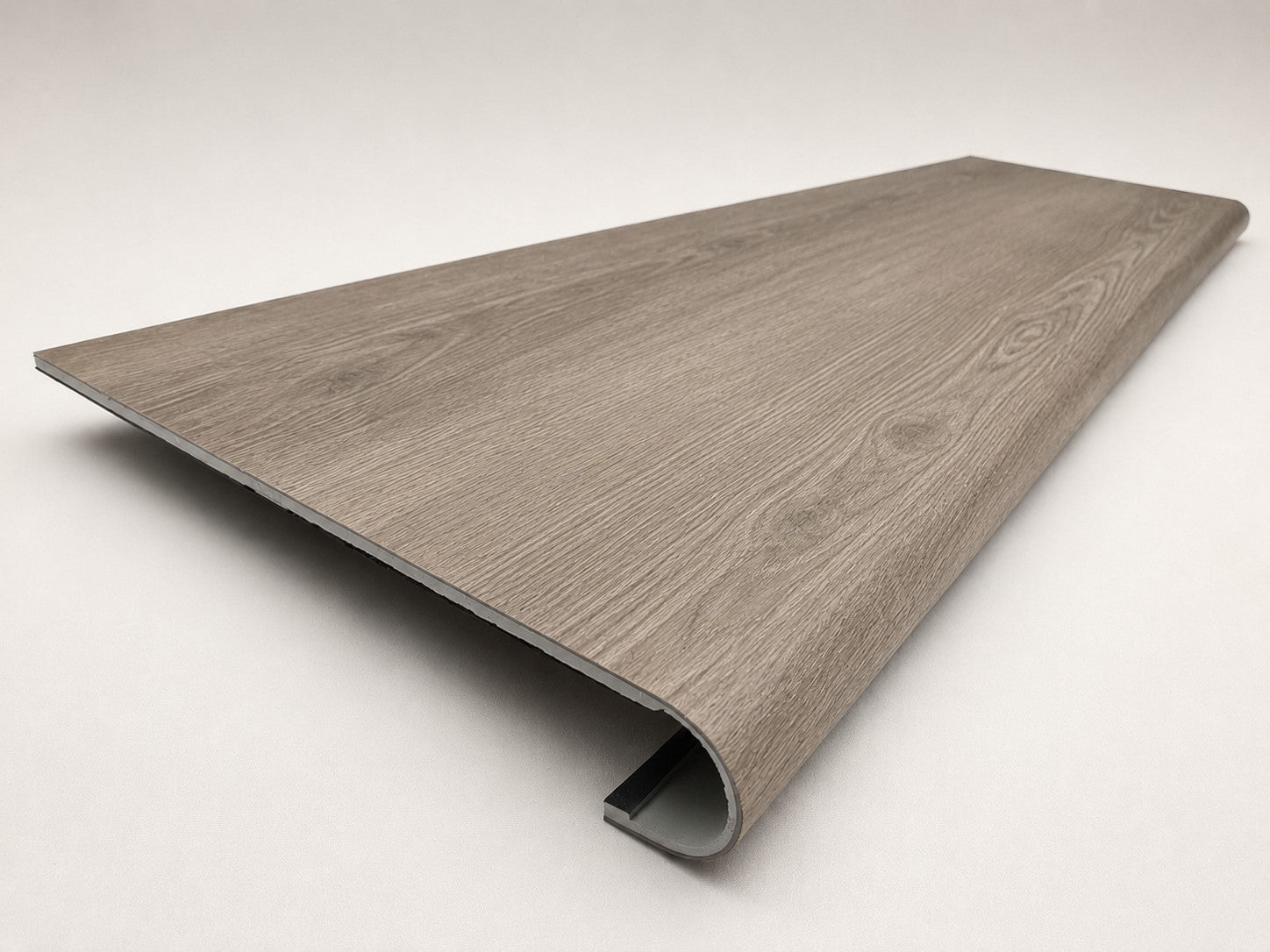 Custom round-nose stair tread made from Style Selections Ashen Oak flooring. Round profile. Angled view.