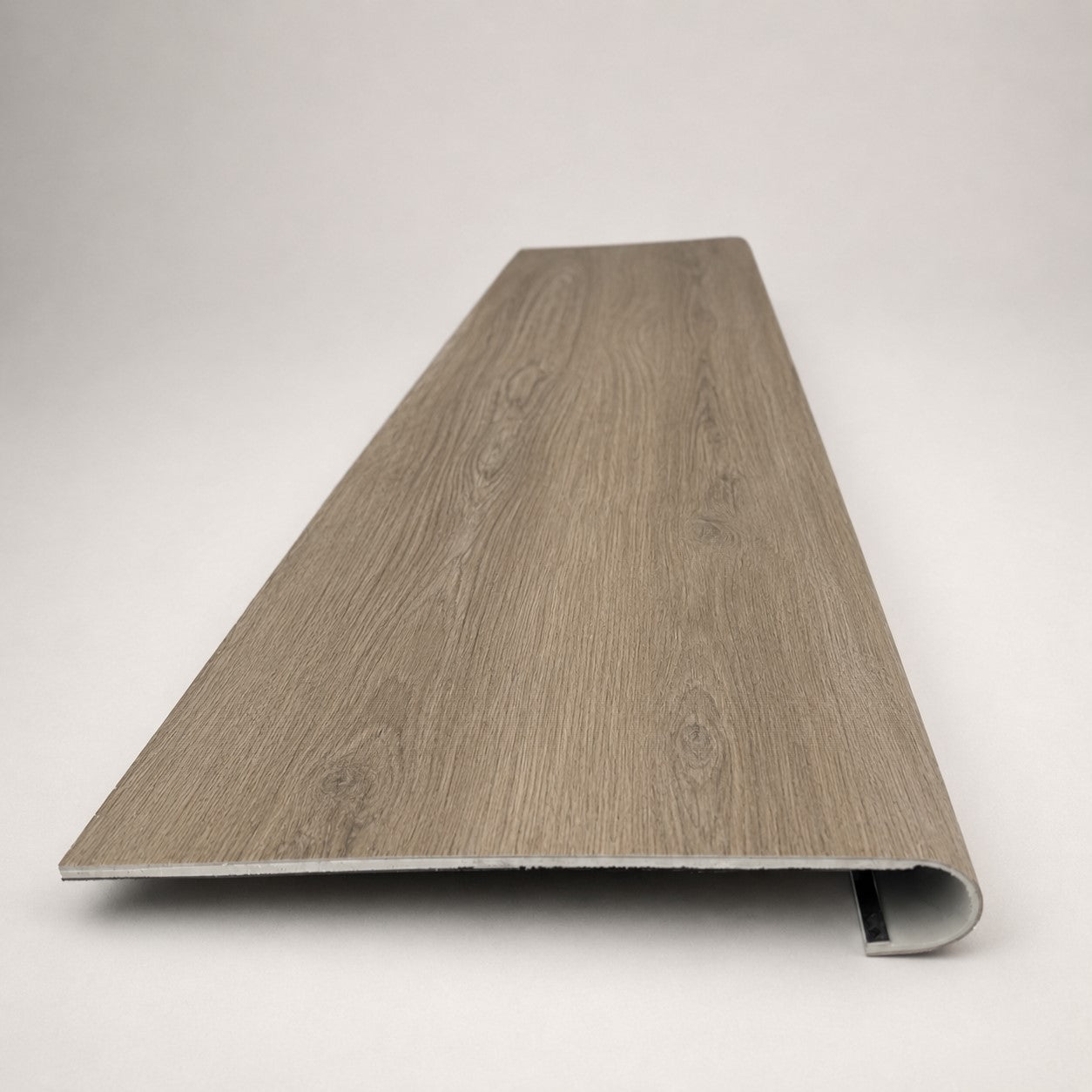 Custom round-nose stair tread made from Style Selections Ashen Oak flooring. Round profile. Front view.