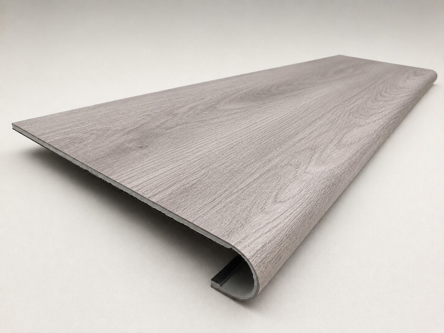 Custom round-nose stair tread made from Style Selections Charleston Oak flooring. Round profile. Angled view.