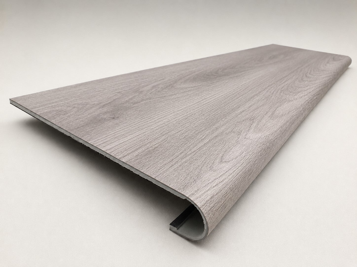 Custom round-nose stair tread made from Style Selections Charleston Oak flooring. Round profile. Angled view.